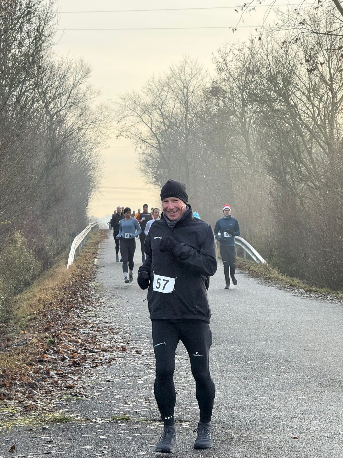 Läuferinnen und Läufer auf der Strecke des Weihnachtslaufs 2025, teils mit Weihnachtsmützen