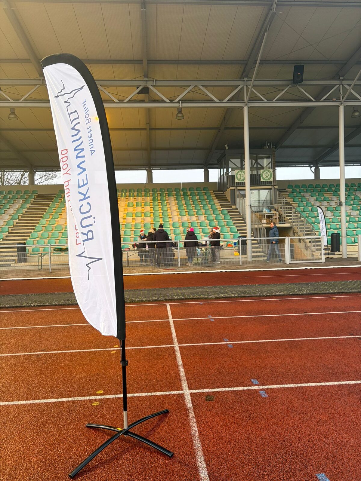 Aufbau des Weihnachtslaufs 2025 im Stadion Im Blumengarten: Helferinnen und Helfer, Tombola-Tisch und Vereinsfahnen im Morgennebel