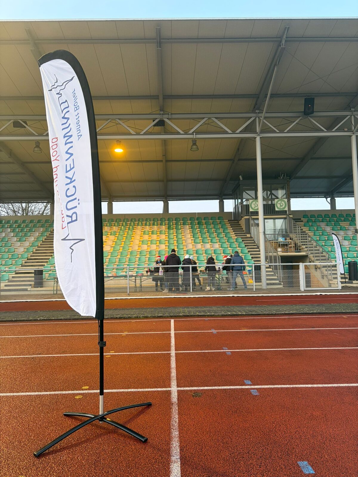 Aufbau des Weihnachtslaufs 2025 im Stadion Im Blumengarten: Helferinnen und Helfer, Tombola-Tisch und Vereinsfahnen im Morgennebel