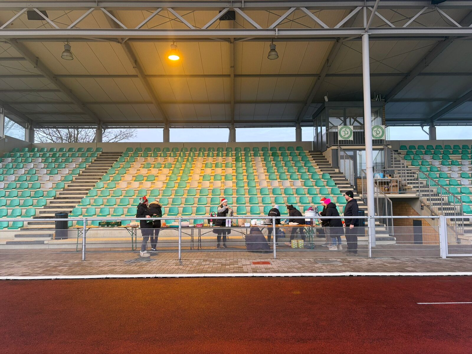 Aufbau des Weihnachtslaufs 2025 im Stadion Im Blumengarten: Helferinnen und Helfer, Tombola-Tisch und Vereinsfahnen im Morgennebel
