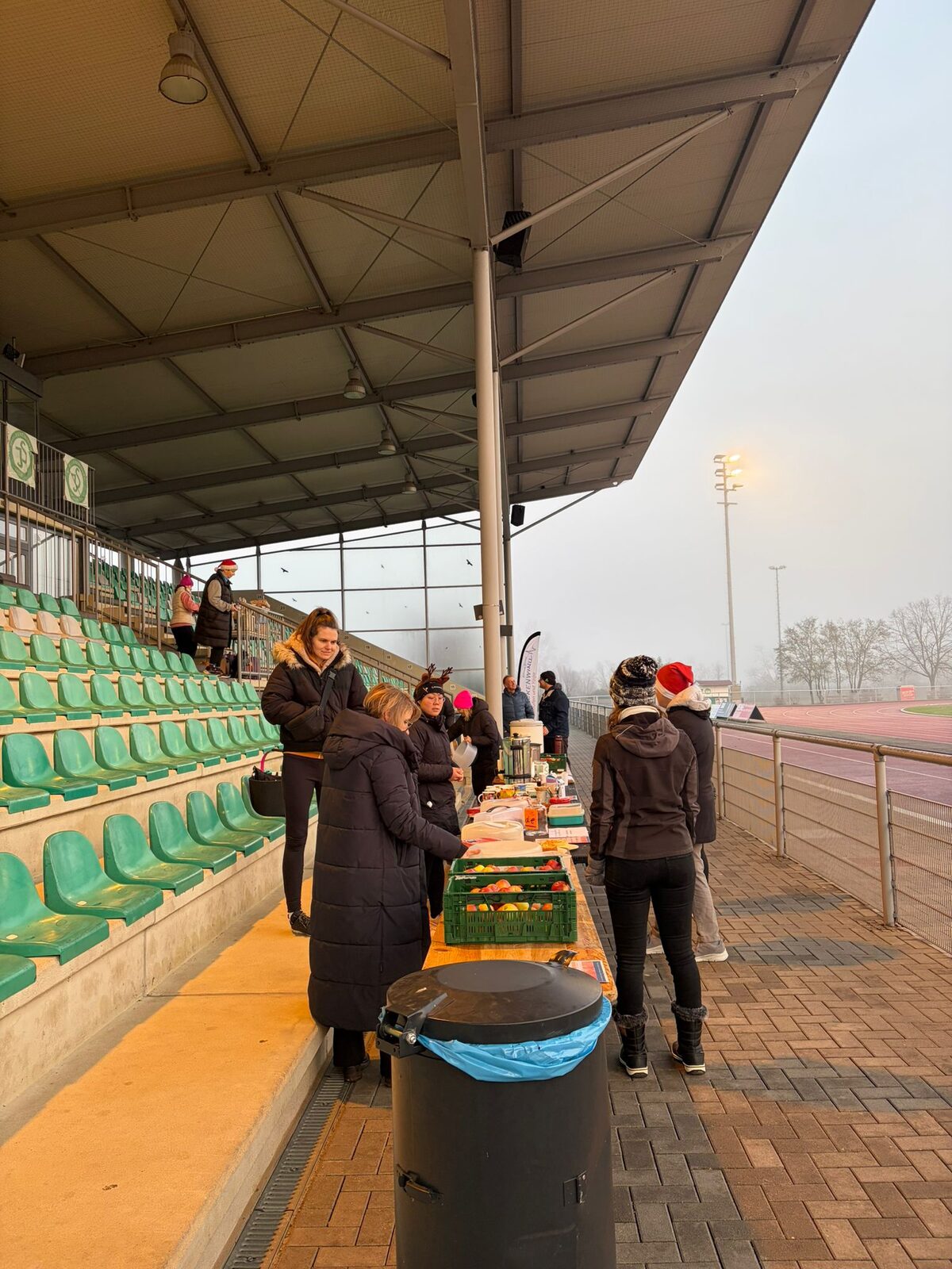 Aufbau des Weihnachtslaufs 2025 im Stadion Im Blumengarten: Helferinnen und Helfer, Tombola-Tisch und Vereinsfahnen im Morgennebel