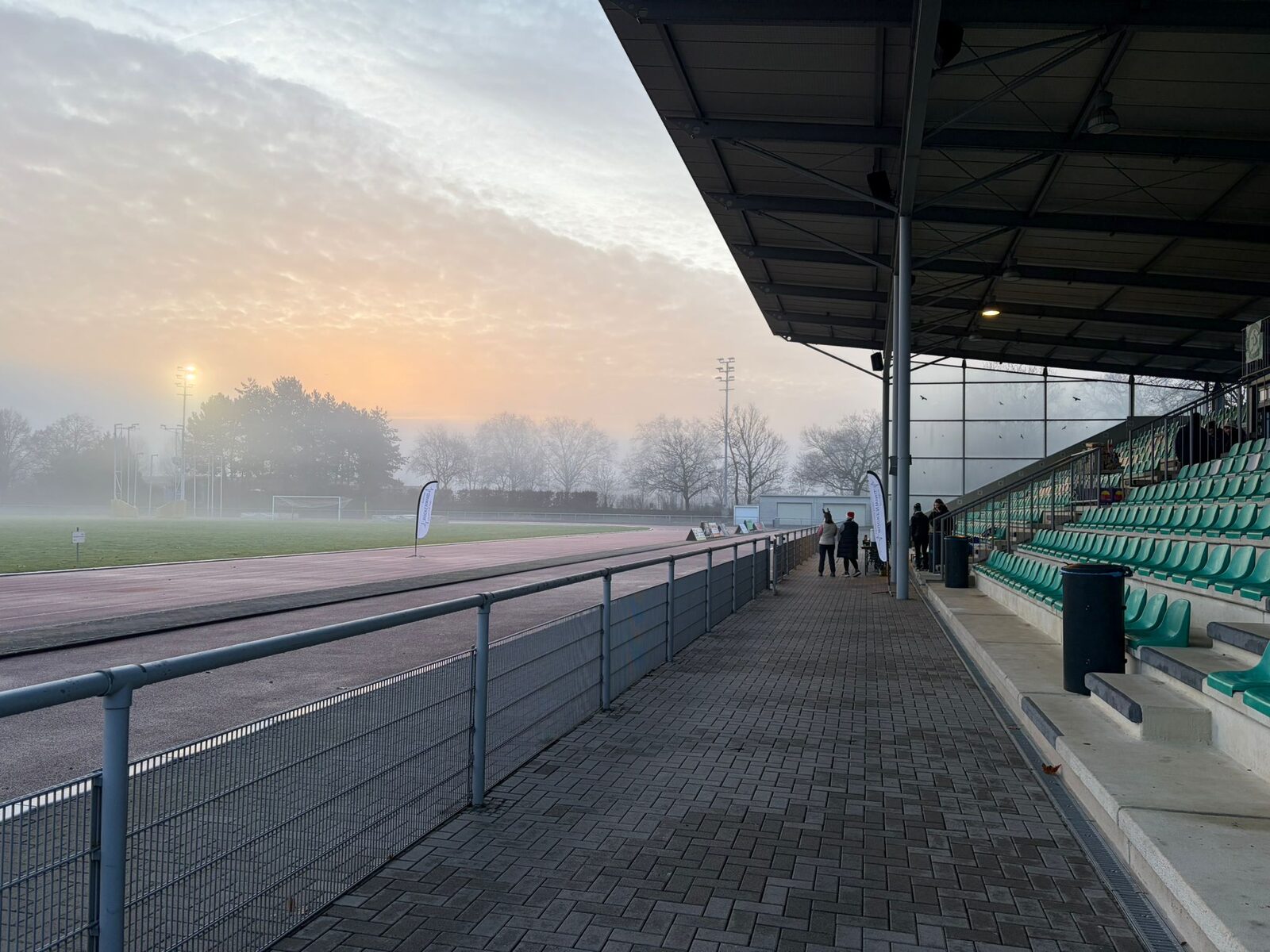 Aufbau des Weihnachtslaufs 2025 im Stadion Im Blumengarten: Helferinnen und Helfer, Tombola-Tisch und Vereinsfahnen im Morgennebel