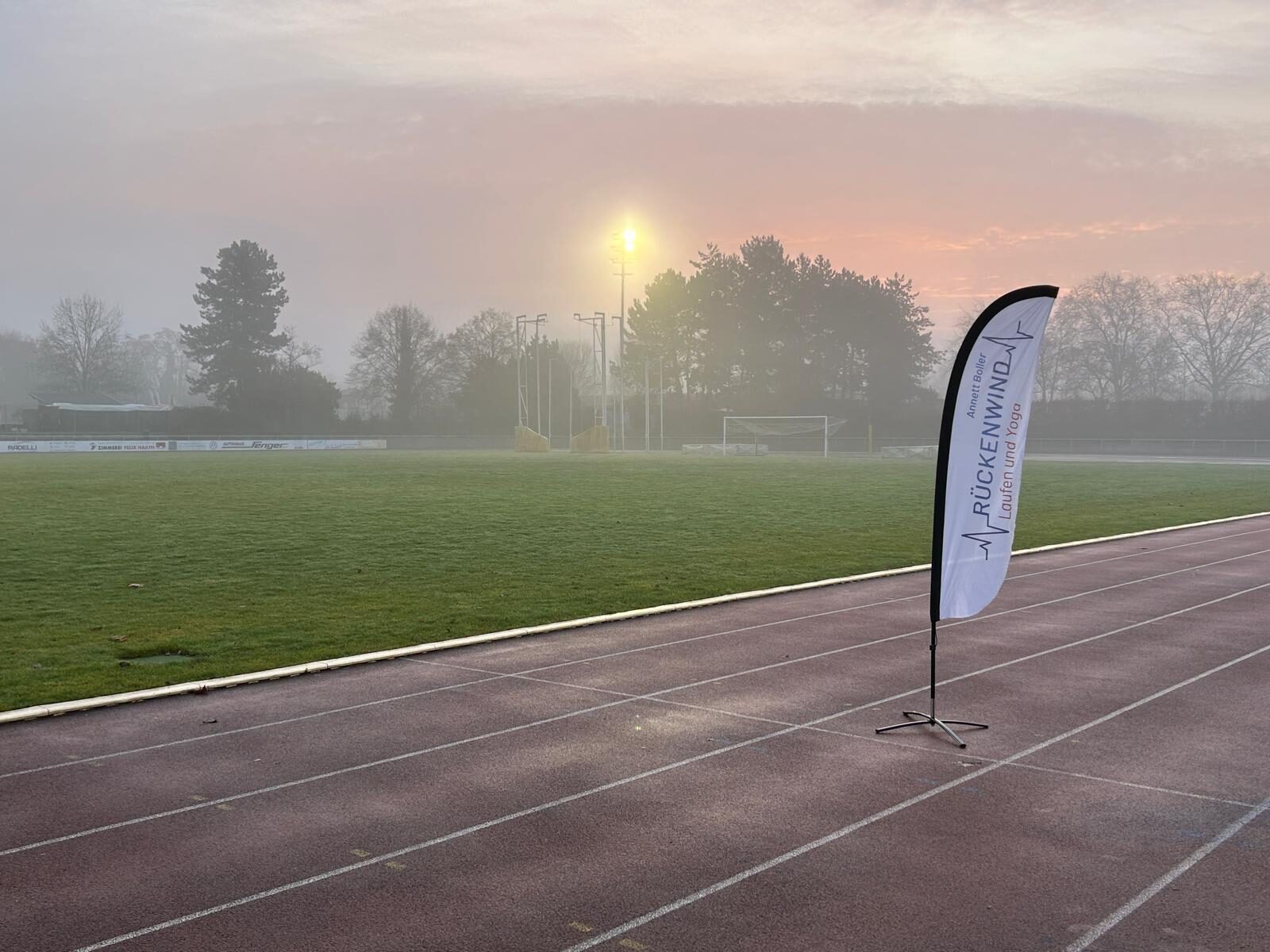 Aufbau des Weihnachtslaufs 2025 im Stadion Im Blumengarten: Helferinnen und Helfer, Tombola-Tisch und Vereinsfahnen im Morgennebel